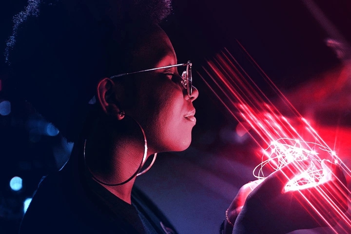 A woman with a bright red light string in her hands
