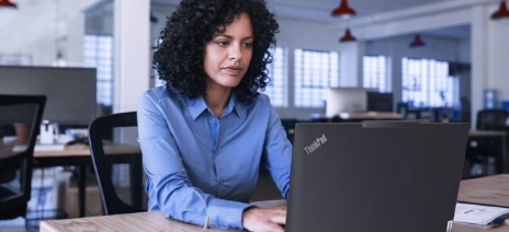 Office worker using a Lenovo ThinkPad laptop.