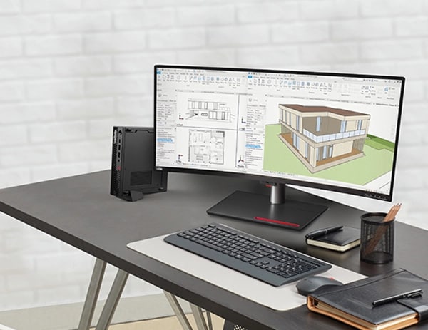 Lenovo ThinkStation P3 Tiny Workstation, stood vertically on desk, next to wireless keyboard, mouse, & dual monitors, showing house design