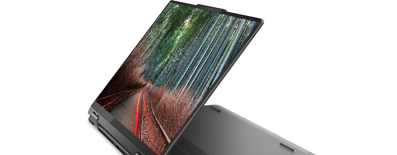 Angle view of the Lenovo Yoga 7 Gen 8 (14” AMD) 2-in-1 laptop in stand mode, with an image of a forest road on the display