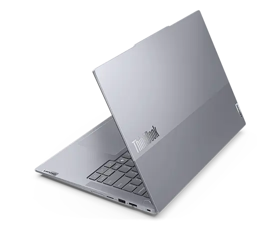 Rear-facing view of Lenovo ThinkBook 14 Gen 6+ (14 inch Intel) laptop, opened, at slight angle, showing top cover, part of keyboard, & left-side ports