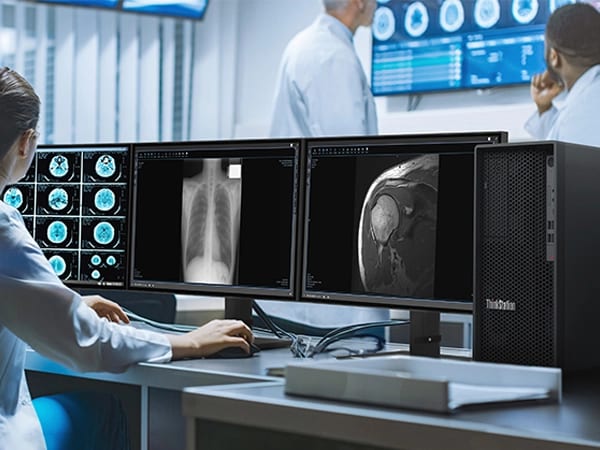 A medical lab featuring a professional working on a diagnostic report on three PC monitors, using the Lenovo ThinkStation P2 Tower workstation for handling heavy medical data.