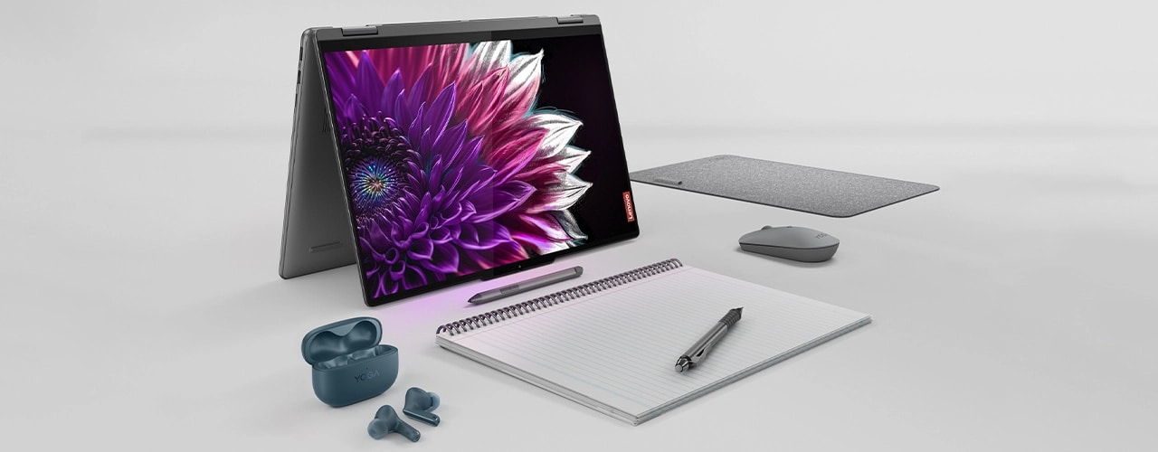 The Yoga 7 2-in-1 Gen 9 (16 Intel) in tent mode surrounded by various accessories and a notebook and pen