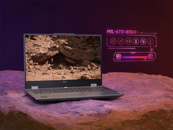 Ноутбук Lenovo LOQ 15AHP9, стоящий на камне, вид спереди; значки сбоку обозначают долговечность под текстом MIL-STD-810H.