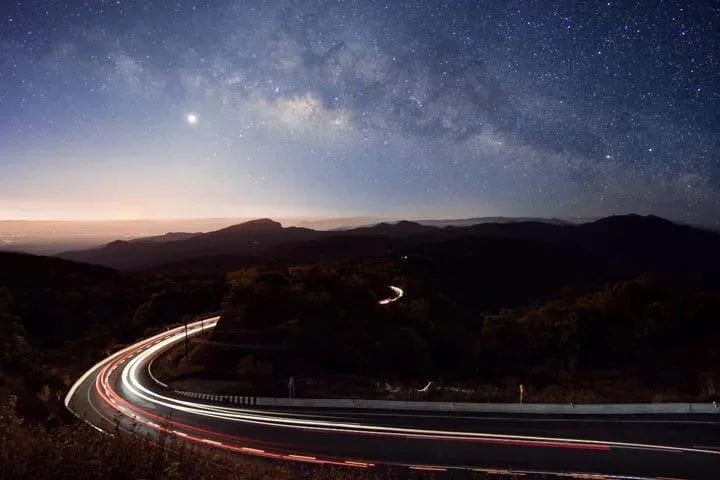 An exposure of a highway along a mountain at night 