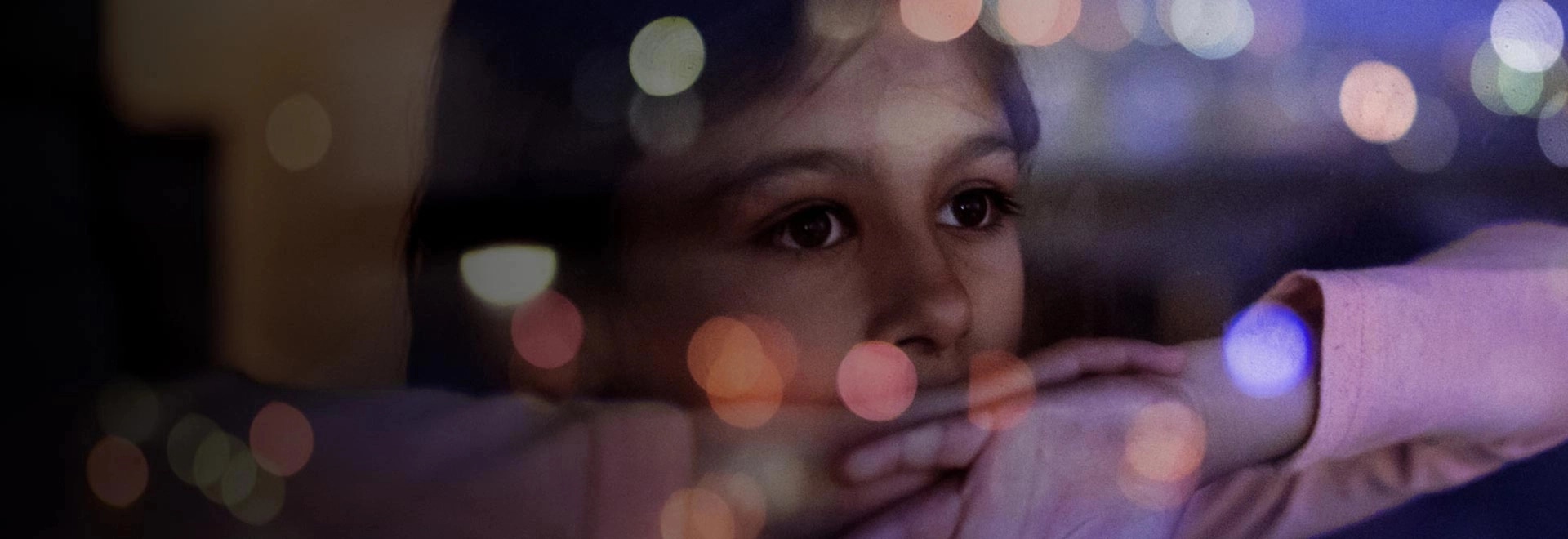 Un enfant regardant par la fenêtre la nuit