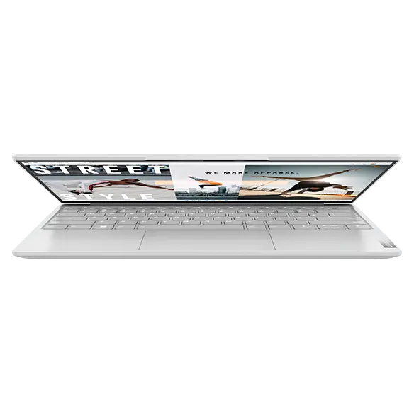 Forward-facing Yoga Slim 7i Carbon laptop, opened 45 degrees, showing keyboard, trackpad, & display with beach scene