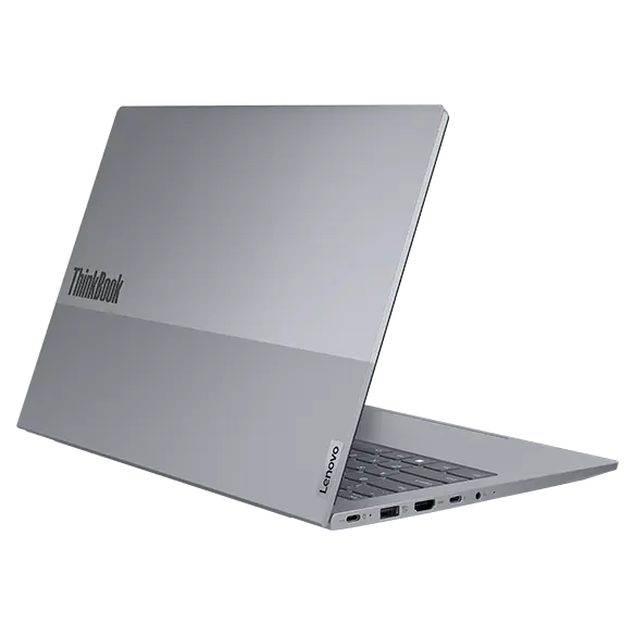 Rear, left side view of Lenovo ThinkBook 14 Gen 7 (14 inch Intel) laptop opened at an acute angle, focusing its top cover highlighting the ThinkBook logo & its five visible ports.