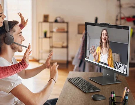 A group of people smiling and looking at a woman on a video call on a Lenovo IdeaCentre AIO Gen 10 (27