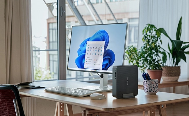 The IdeaCentre Mini (Intel) desktop PC, mounted on a stand on a home office desktop, and surrounded by a keyboard, mouse and monitor.מחשב נייח IdeaCentre Mini 01IRH10R 91B20026YS מבית Lenovo
