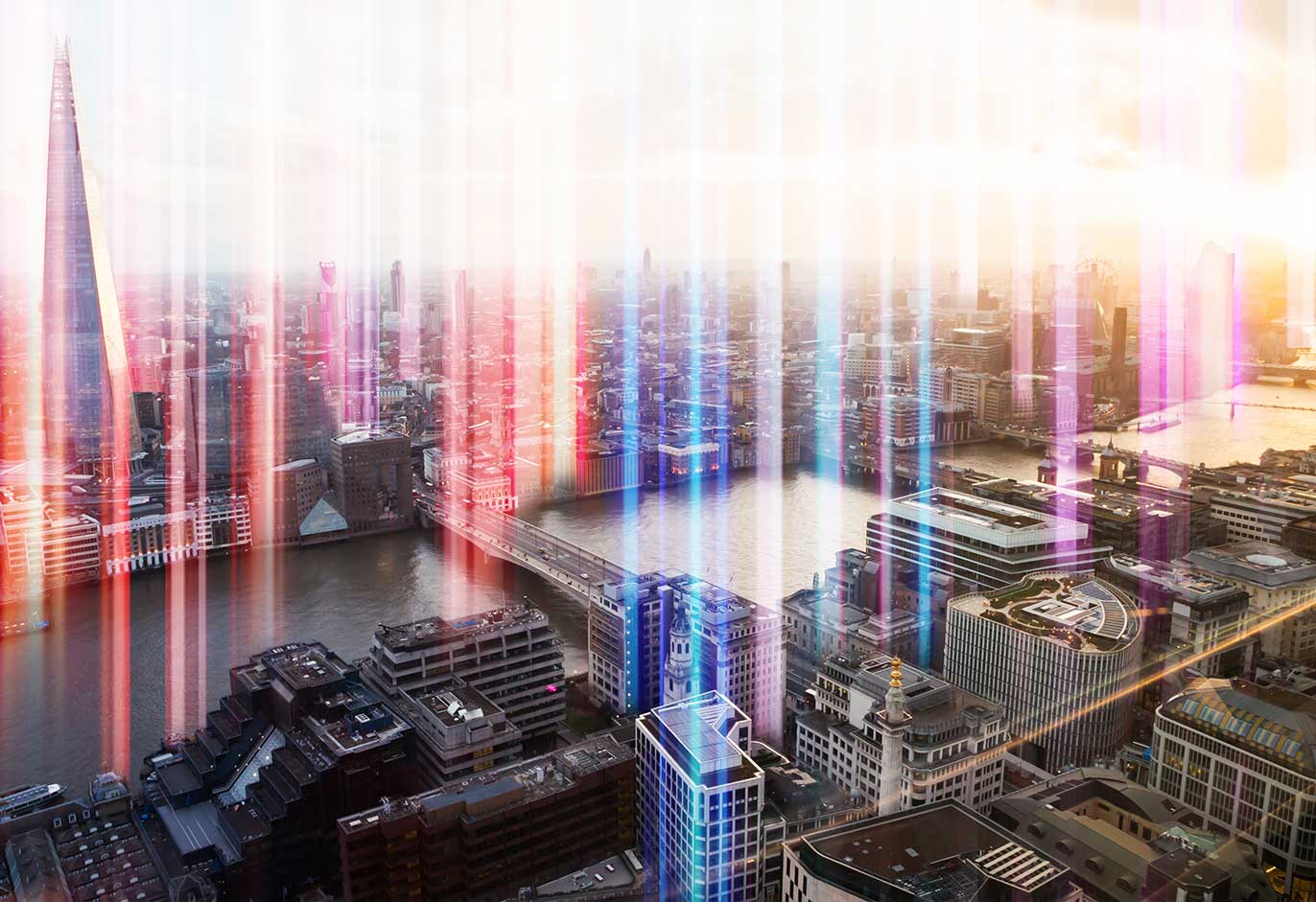 A city skyline with colorful digital light effects overlaying the scene, creating a futuristic and vibrant atmosphere.