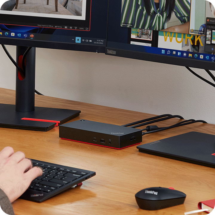 A person is using the keyboard and the ThinkPad dock which connects two monitors at home.