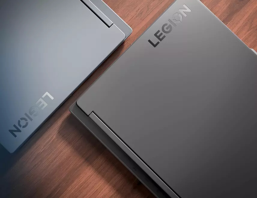 Overhead view of two closed Lenovo Legion Slim 5 laptops laying edge to edge on a diagonal axis with Legion logos visible.