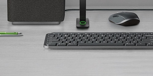 Keyboard, mouse, speaker, pen on desktop