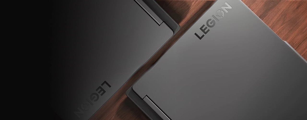 Overhead view of two closed Lenovo Legion Slim 5 laptops laying edge to edge on a diagonal axis with Legion logos visible.