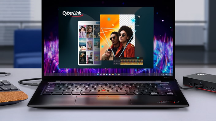 The image shows an open Lenovo laptop. The screen displays a photo editing program,  "CyberLink," featuring several thumbnail images and a colorful design that includes two people in the center. On the table, there are some objects like a mouse and a coaster.