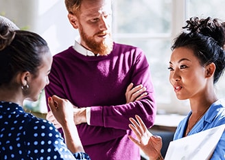 Two desktop workstations with Lenovo monitors displaying data dashboards, paired with compact Lenovo ThinkCentre PCs and keyboards, set up on a white desk in a bright modern office