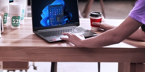 L’image en gros plan d’une femme travaillant sur un bureau avec son portable ouvert.