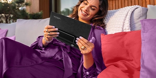 Femme assise sur un canapé avec une tablette Lenovo