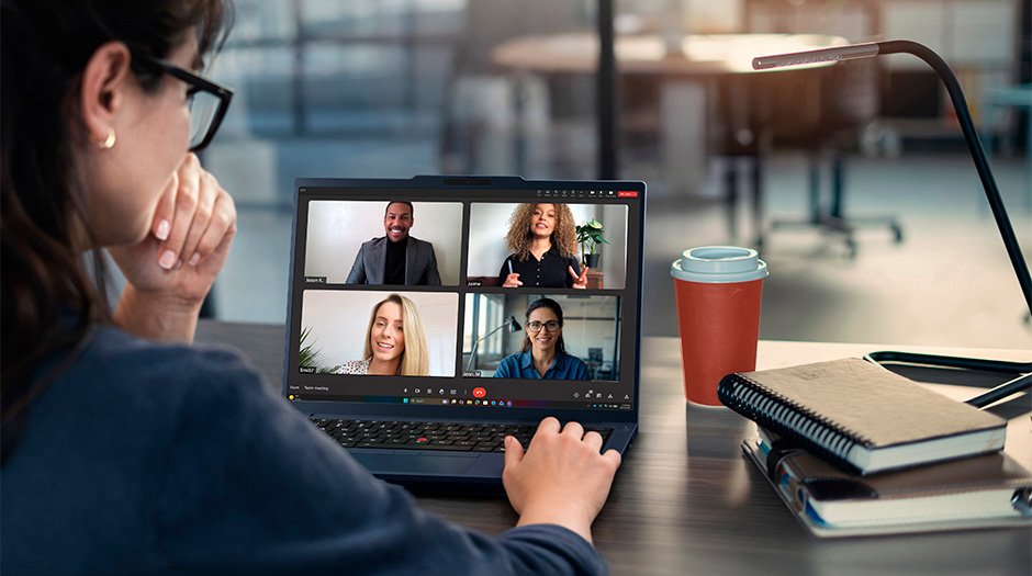 A woman at a desk talks with colleagues on a videocall on the Lenovo ThinkPad T14 Gen 7 (14” AMD) laptop.