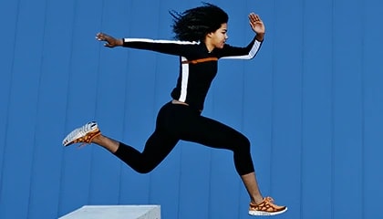 Athlete jumping over obstacle. Blue background.