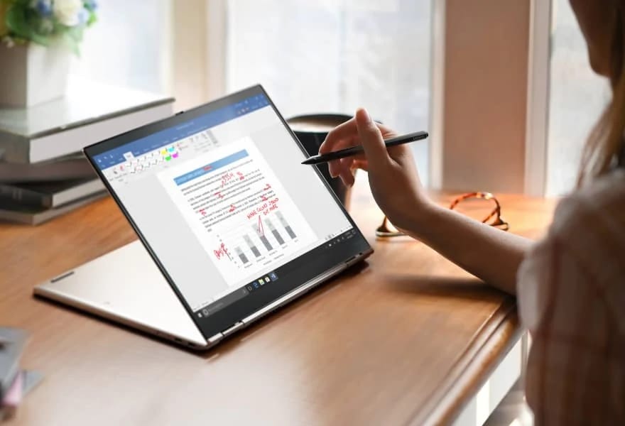 Woman editing document on Lenovo ThinkPad X1 Titanium Yoga by using touch pen to draw on the screen