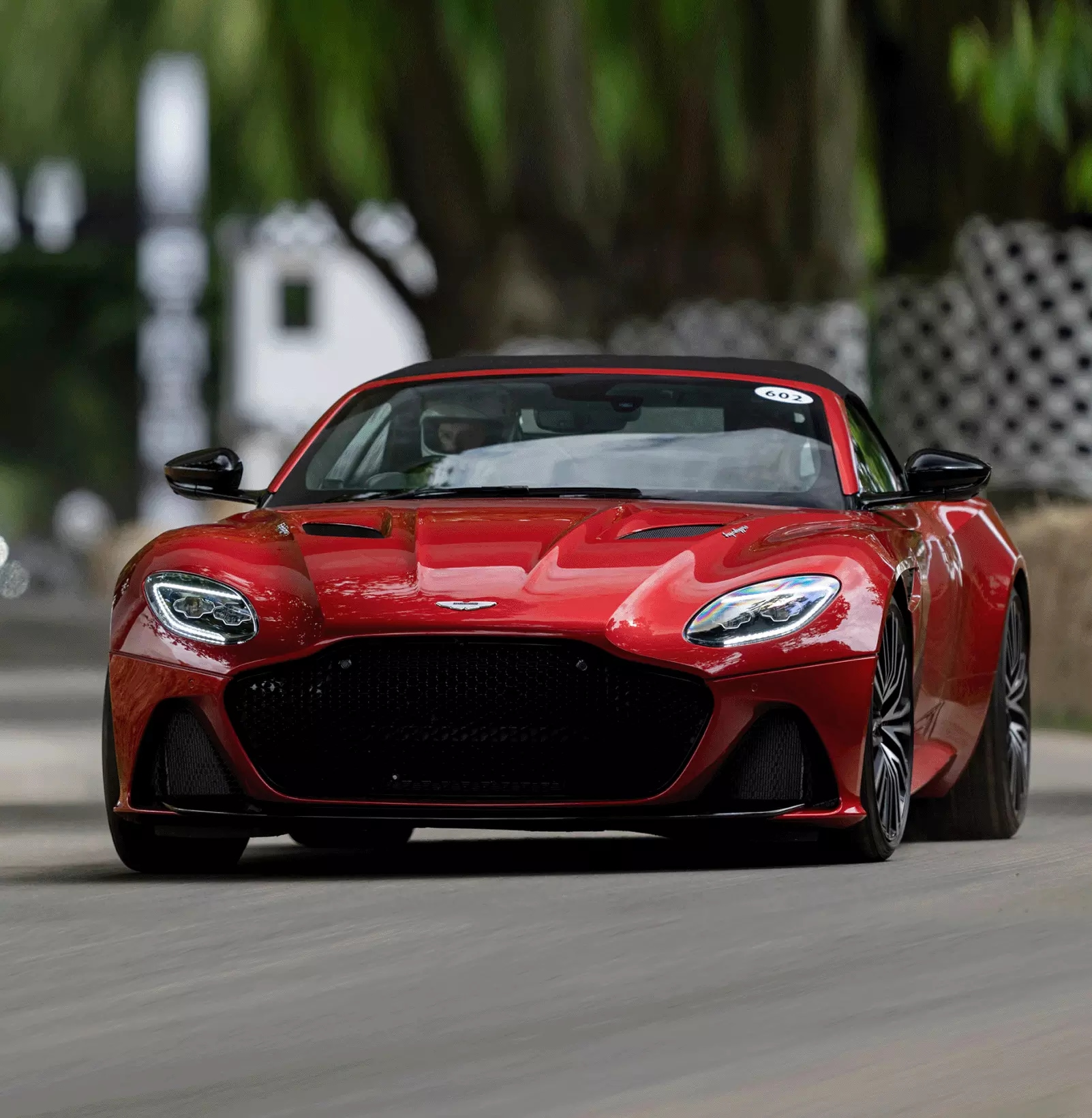 Front view of cherry red Aston Martin driven by racing driver