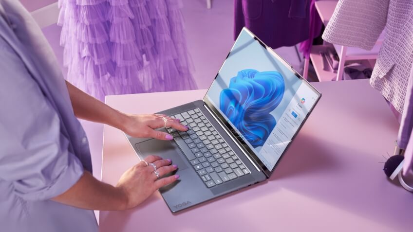 A student in her dorm room having a video chat on her laptop with friends