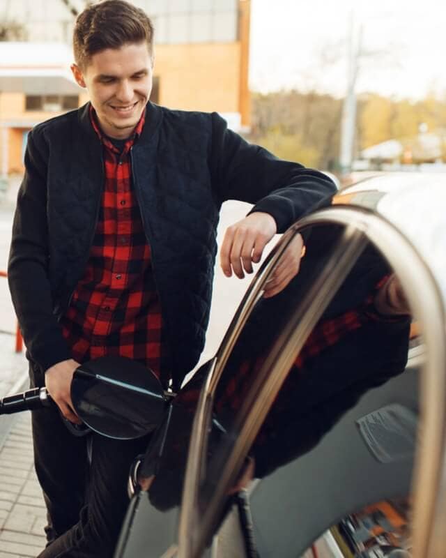 A man filling his car at a filling station