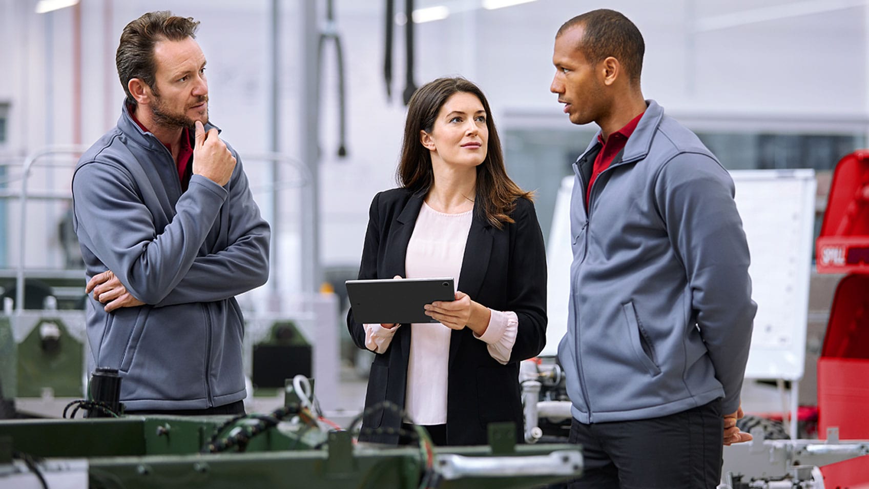 Three people collaborating in a manufacturing facility