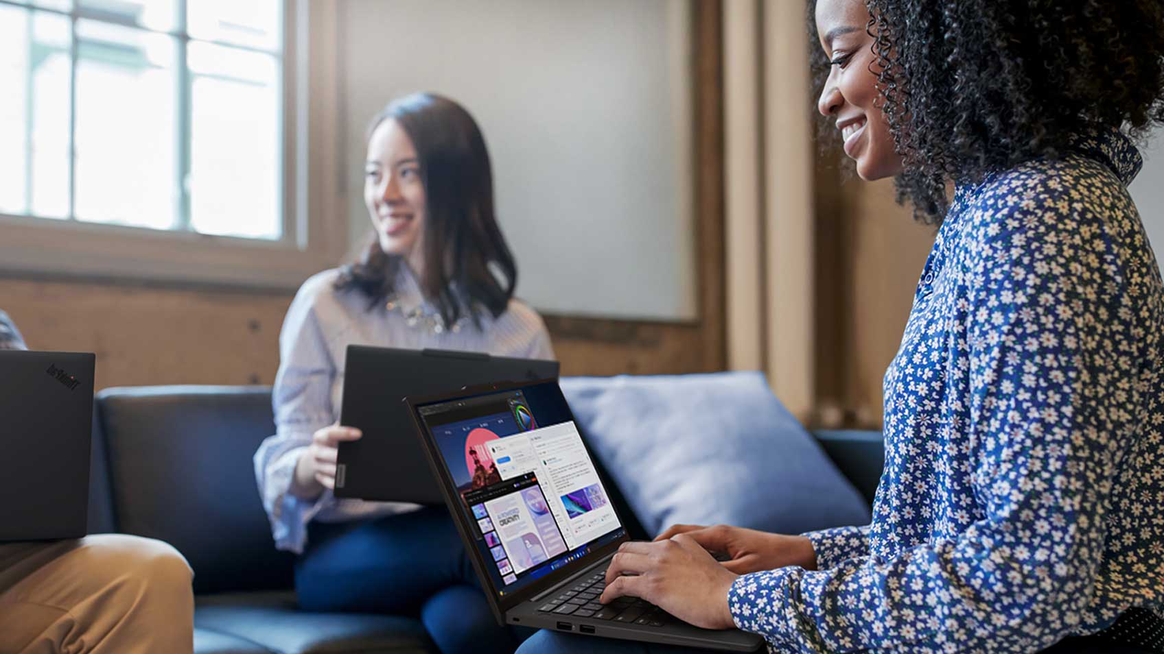 Two women collaborating on their laptops.