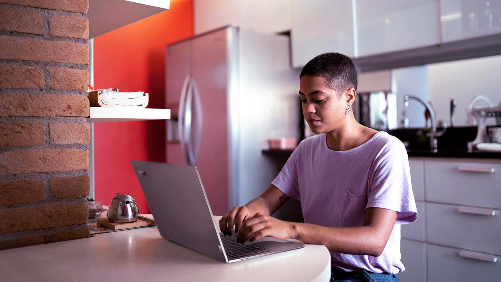 Une femme utilisant son portable à la maison dans la cuisine.