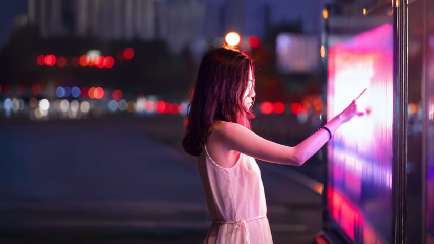 A woman interacting with a futuristic display.