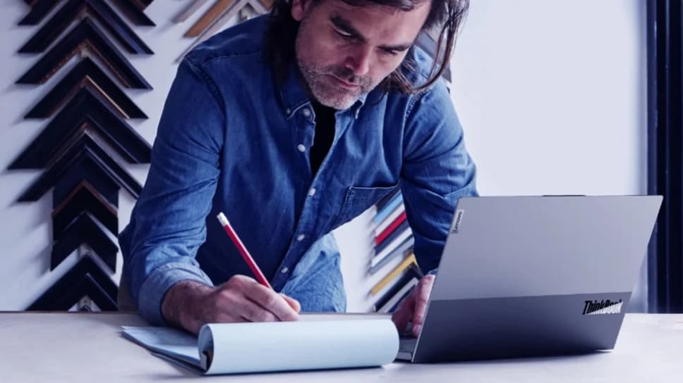 Un homme dans un magasin de cadres utilisant un ThinkBook Lenovo