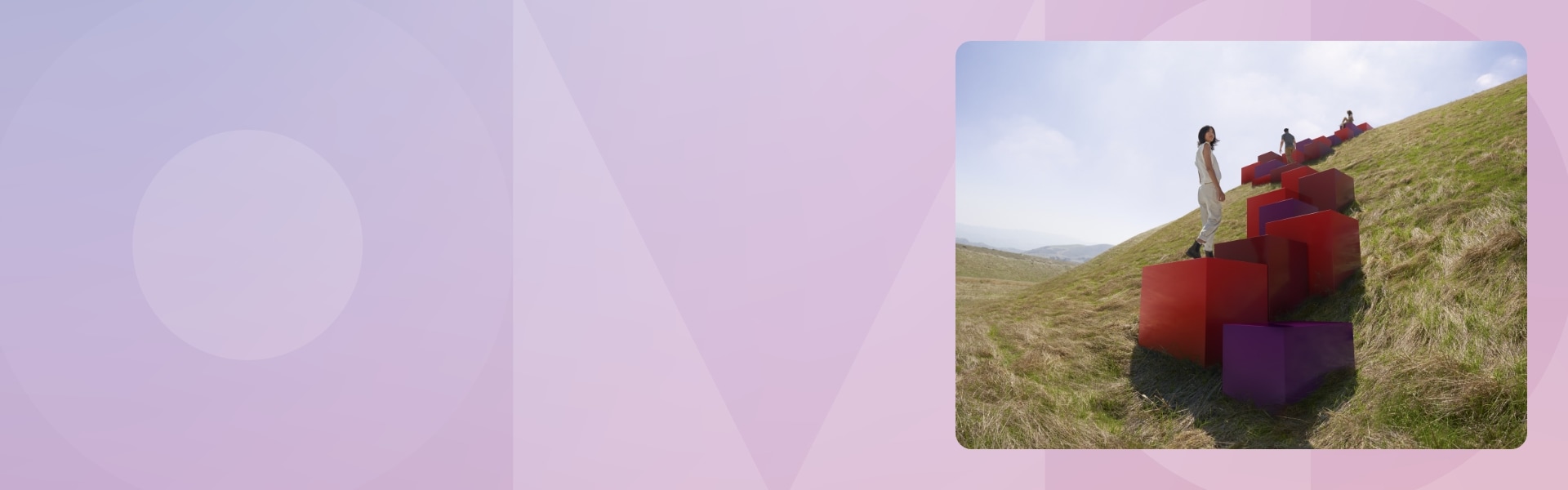 People climbing red and purple cubes that lead up a hill