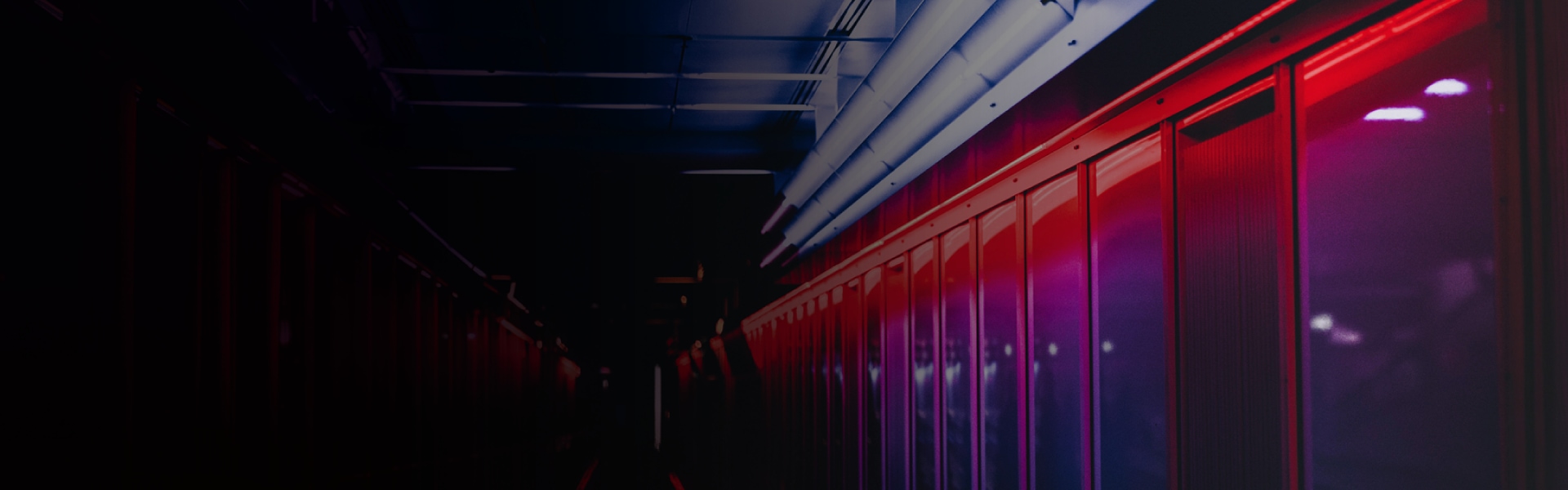 High-tech data center corridor with illuminated server enclosures and dramatic red-purple lighting.