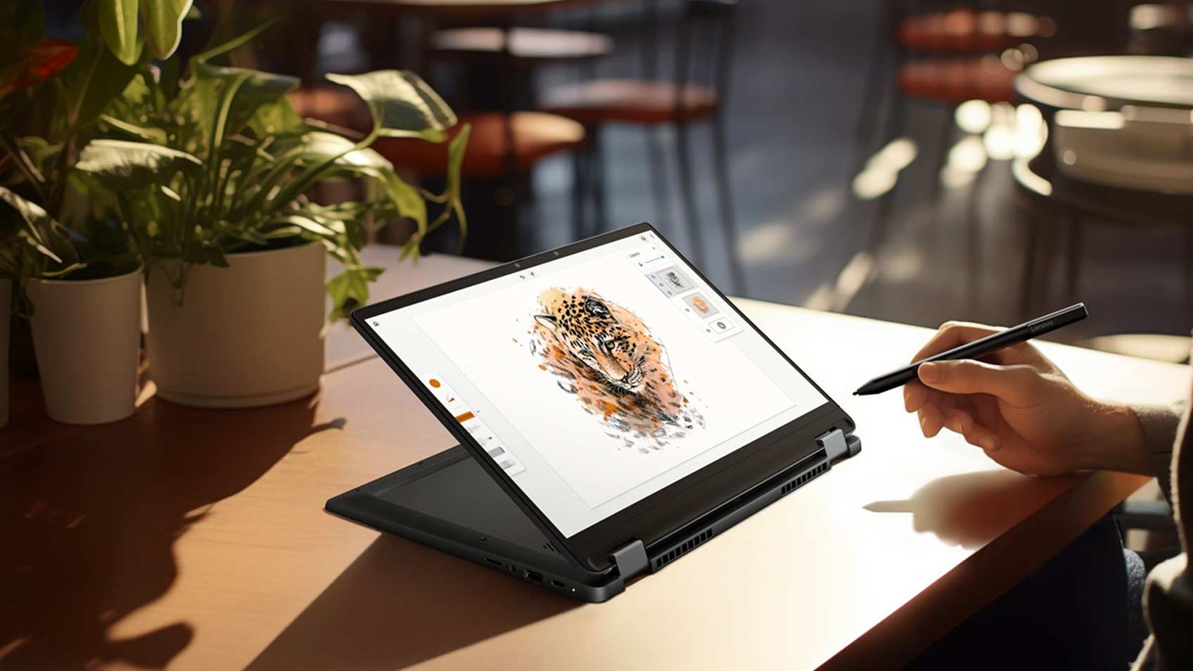Une main tenant un crayon électronique et travaillant sur la conception d’un léopard sur un portable.