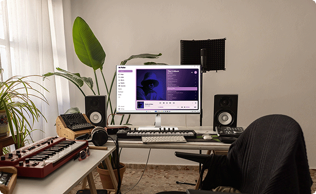 A cozy music production studio setup with the monitor and keyboard.